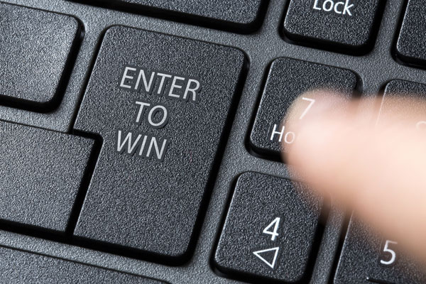 Finger getting ready to push a computer key that reads enter to win