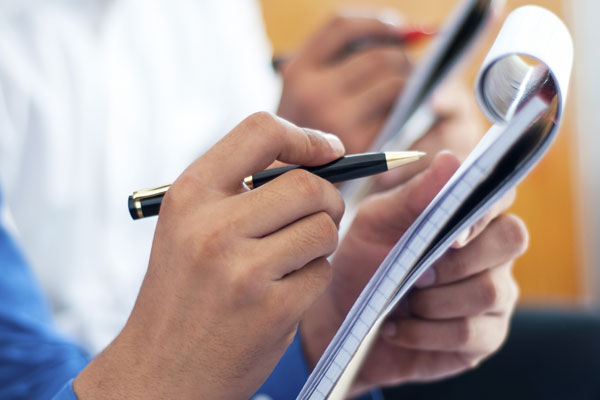 reporter taking notes in notebook